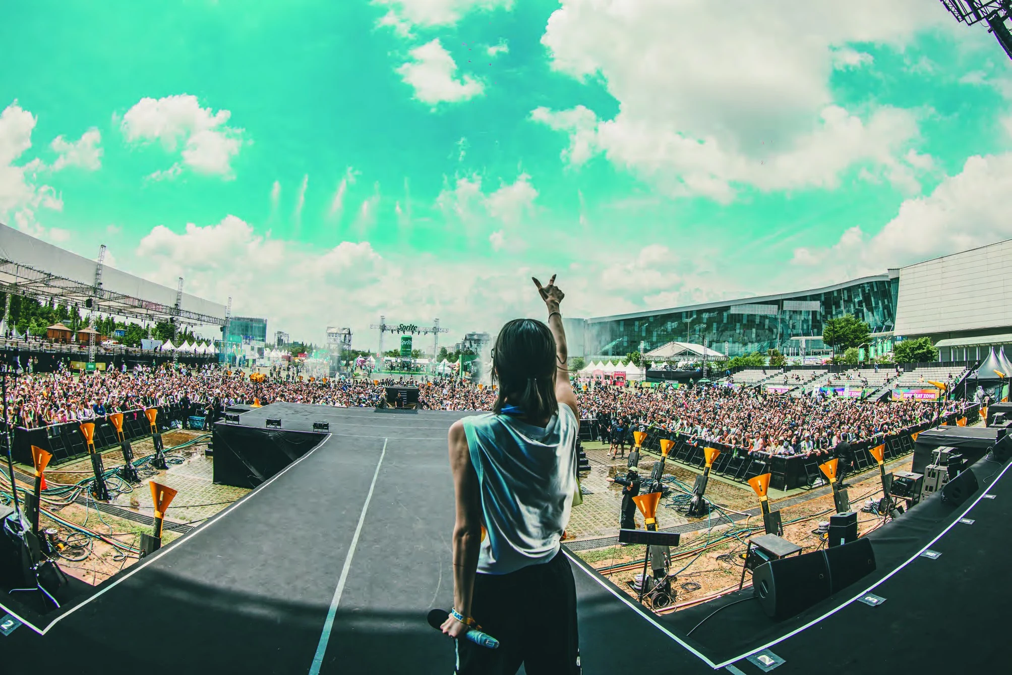 YOONI facing an open-air festival crowd from the DJ booth
